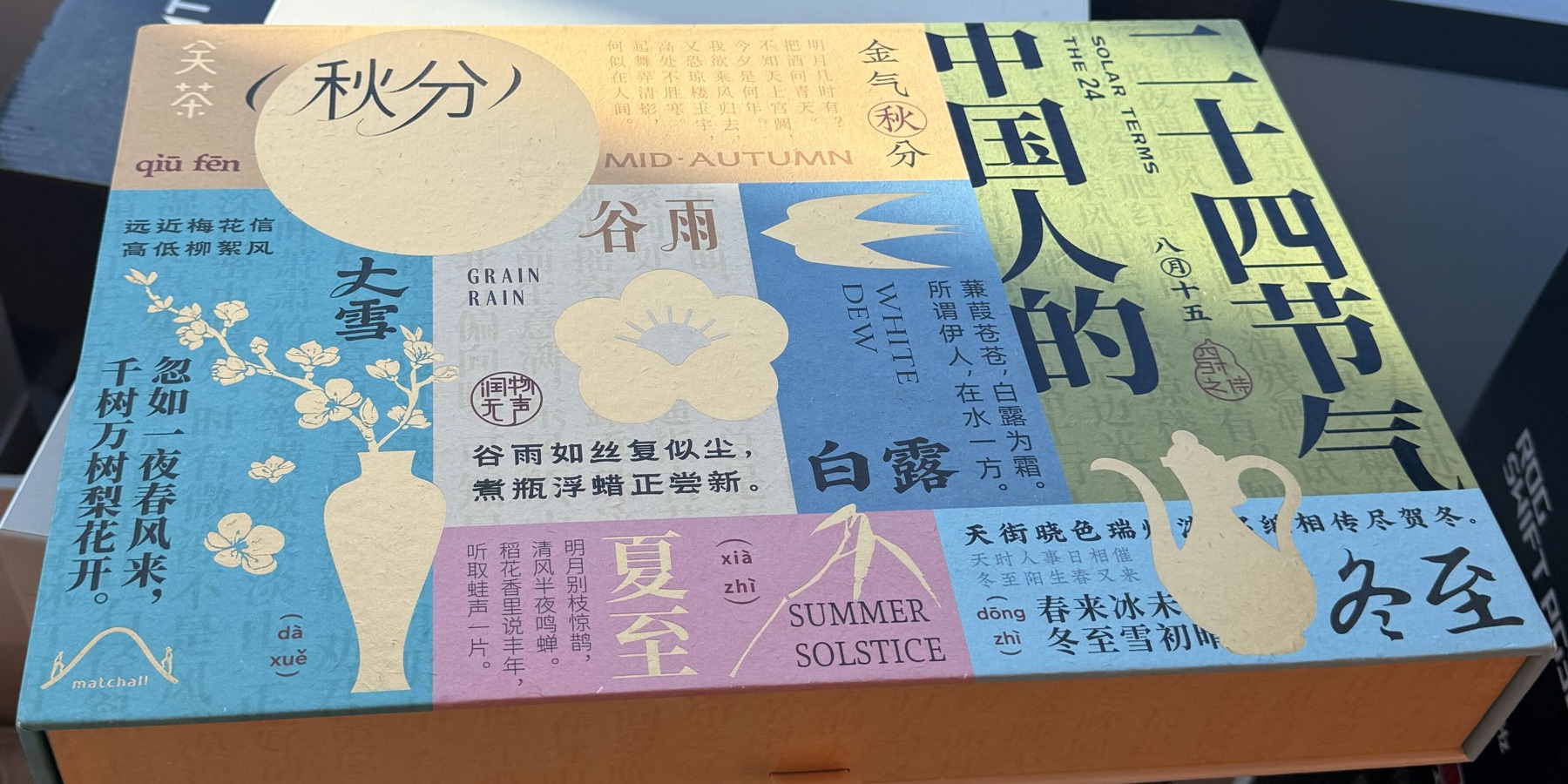 A colourful gift box lid printed with Chinese solar-term names and illustrations, including a plum branch, a swallow and a teapot, with the title The Twenty-Four Solar Terms of the Chinese in large characters.
